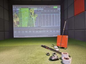 Shows inside Next Level Golf indoor virtual golf studio with golf club custom fitting equipment and Trackman screen with data readings