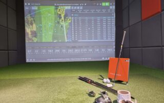 Shows inside Next Level Golf indoor virtual golf studio with golf club custom fitting equipment and Trackman screen with data readings